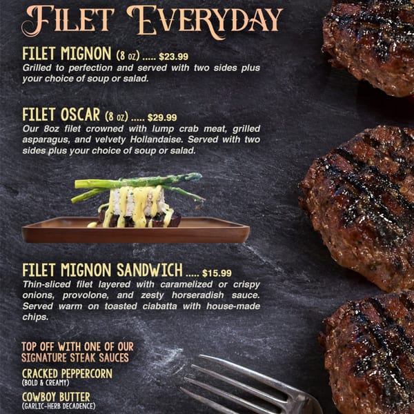 A Filet Oscar with crab meat, asparagus, and hollandaise sauce on a dark slate background.